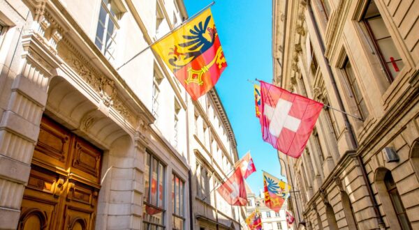 Street view with Swiss flags on the buildings in the old town of Geneva city in Switzerland